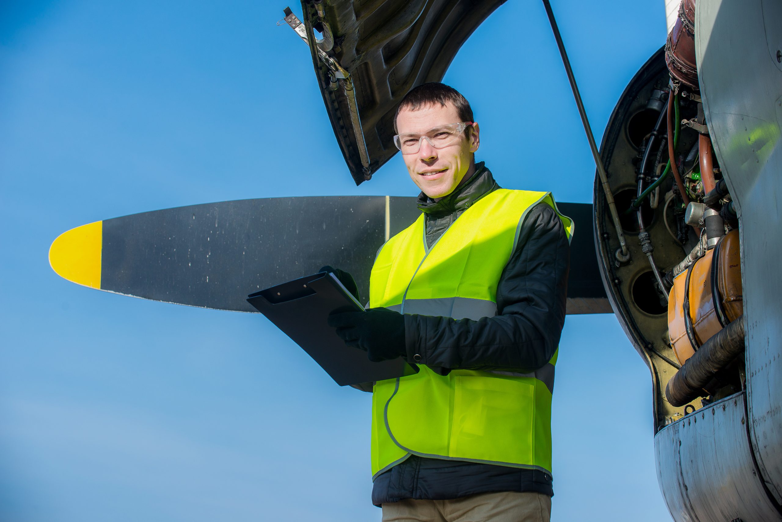 Caucasian male aircraft mechanic facing camera