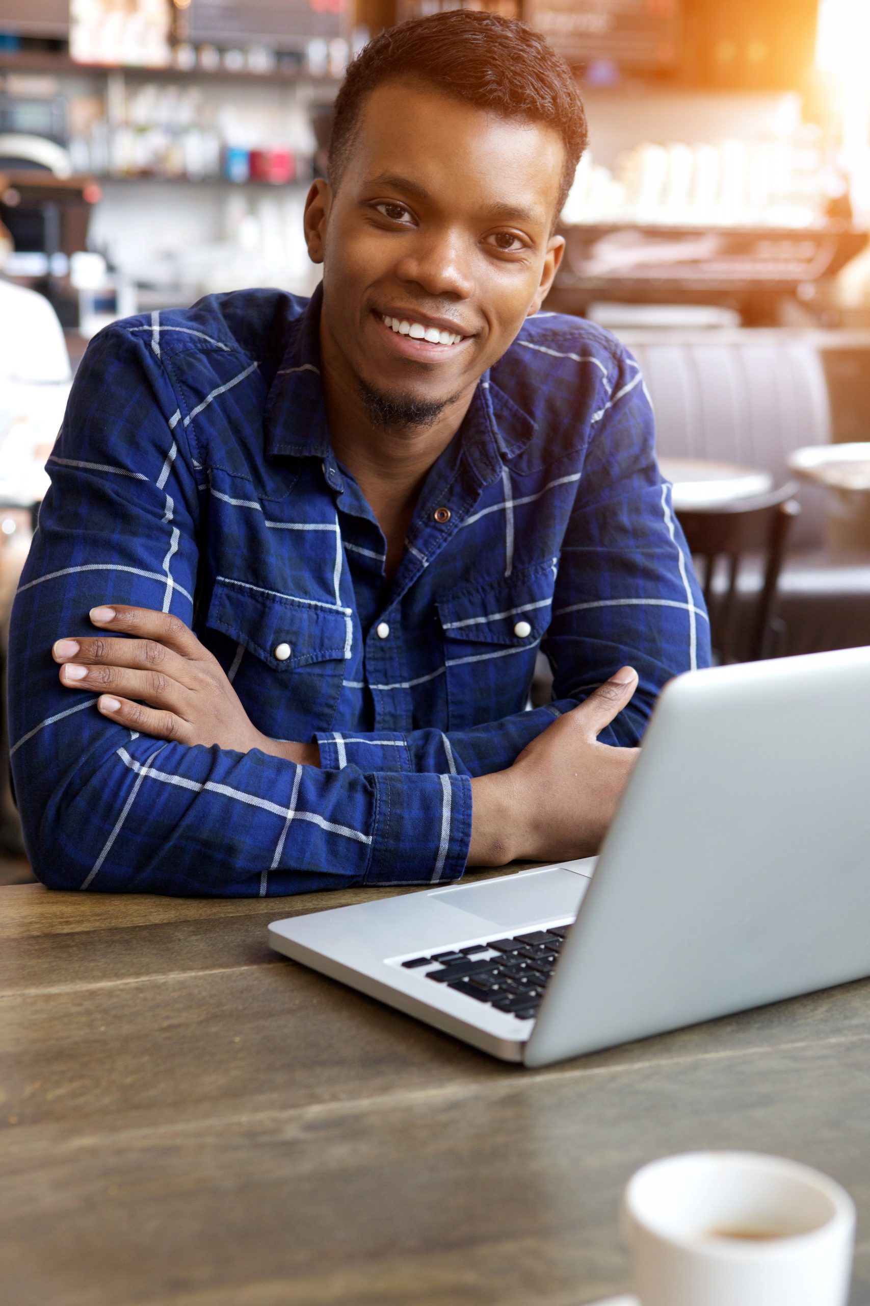 Black male with laptop smiling