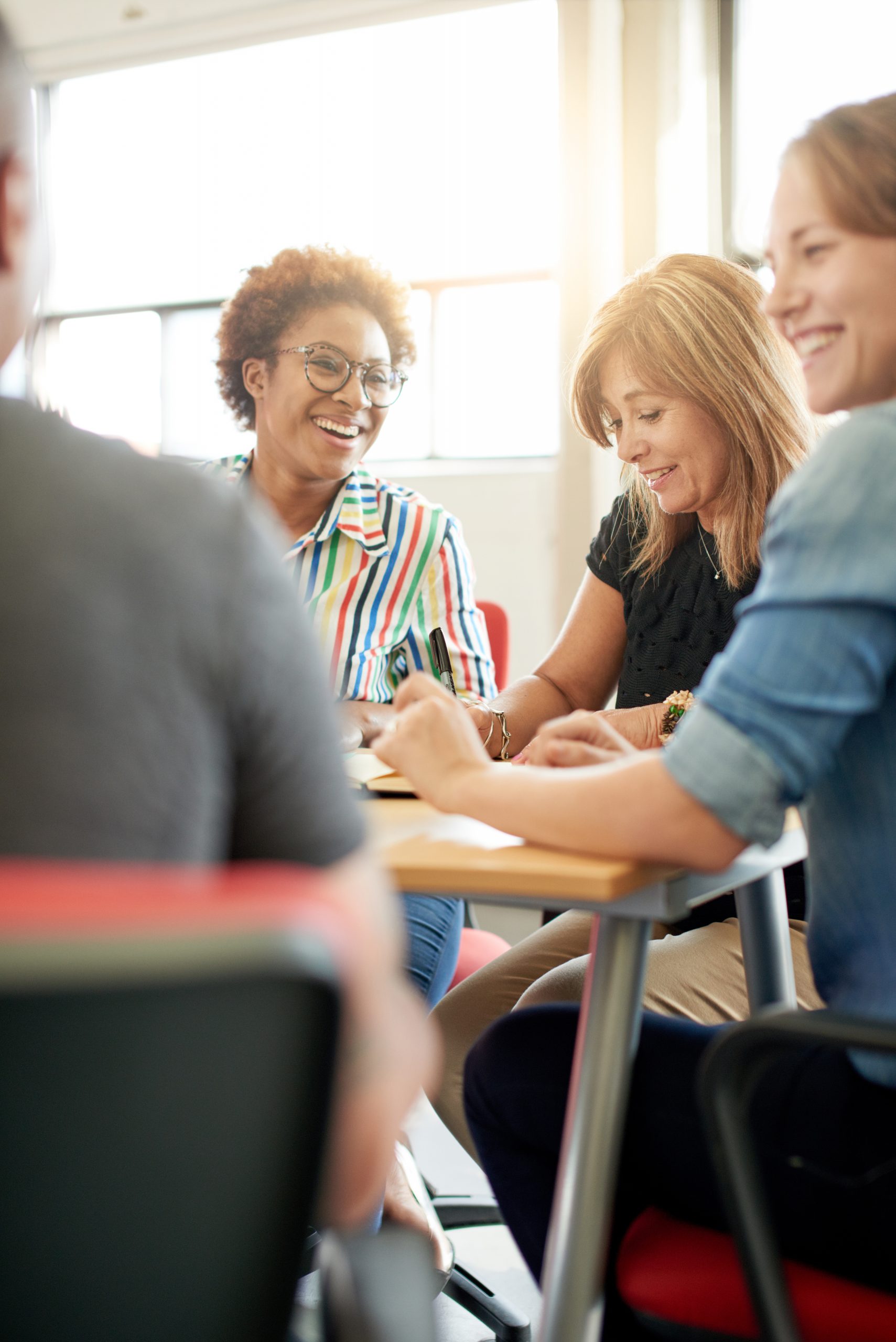 Happy women sitting around table | Adult Learners