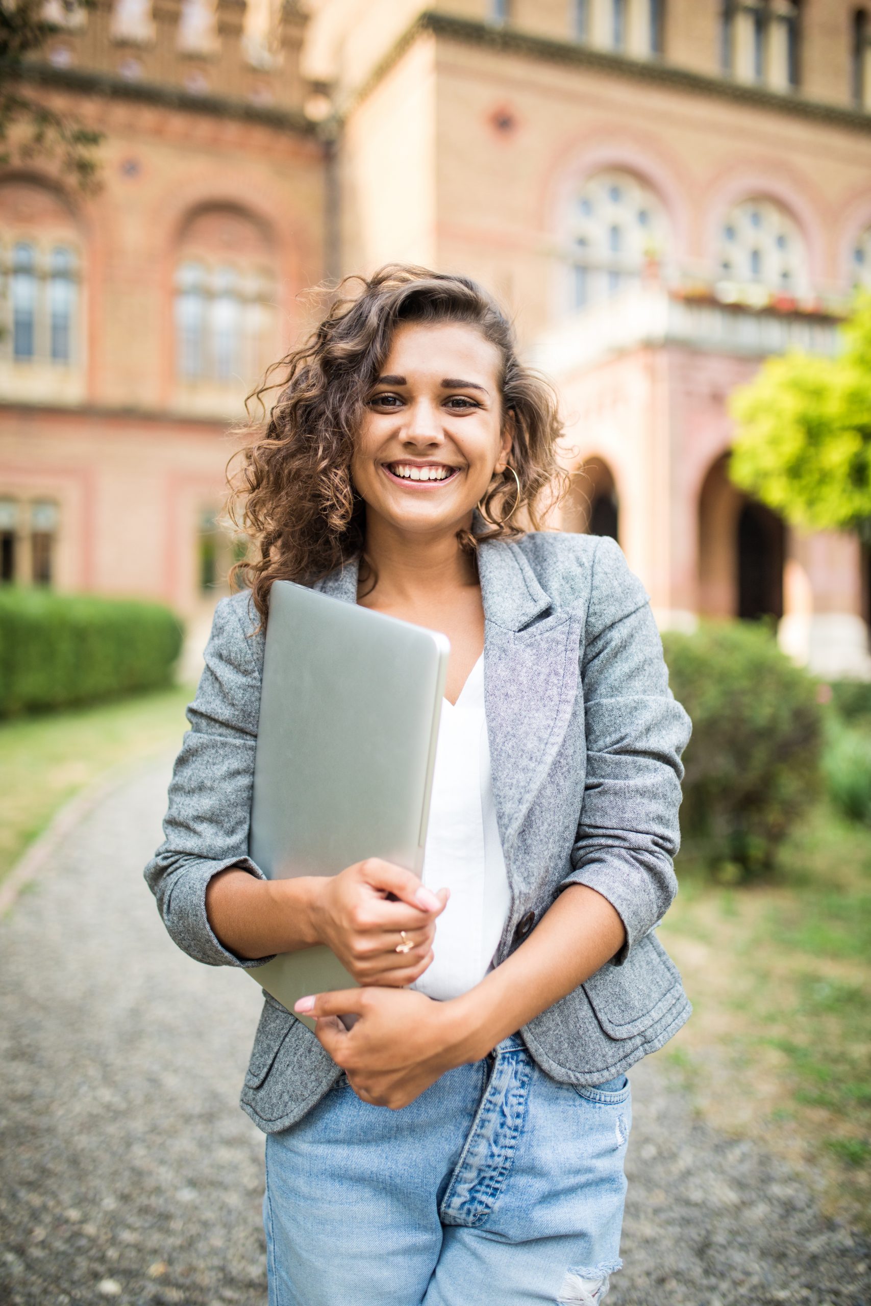 Caucasian female student holding laptop