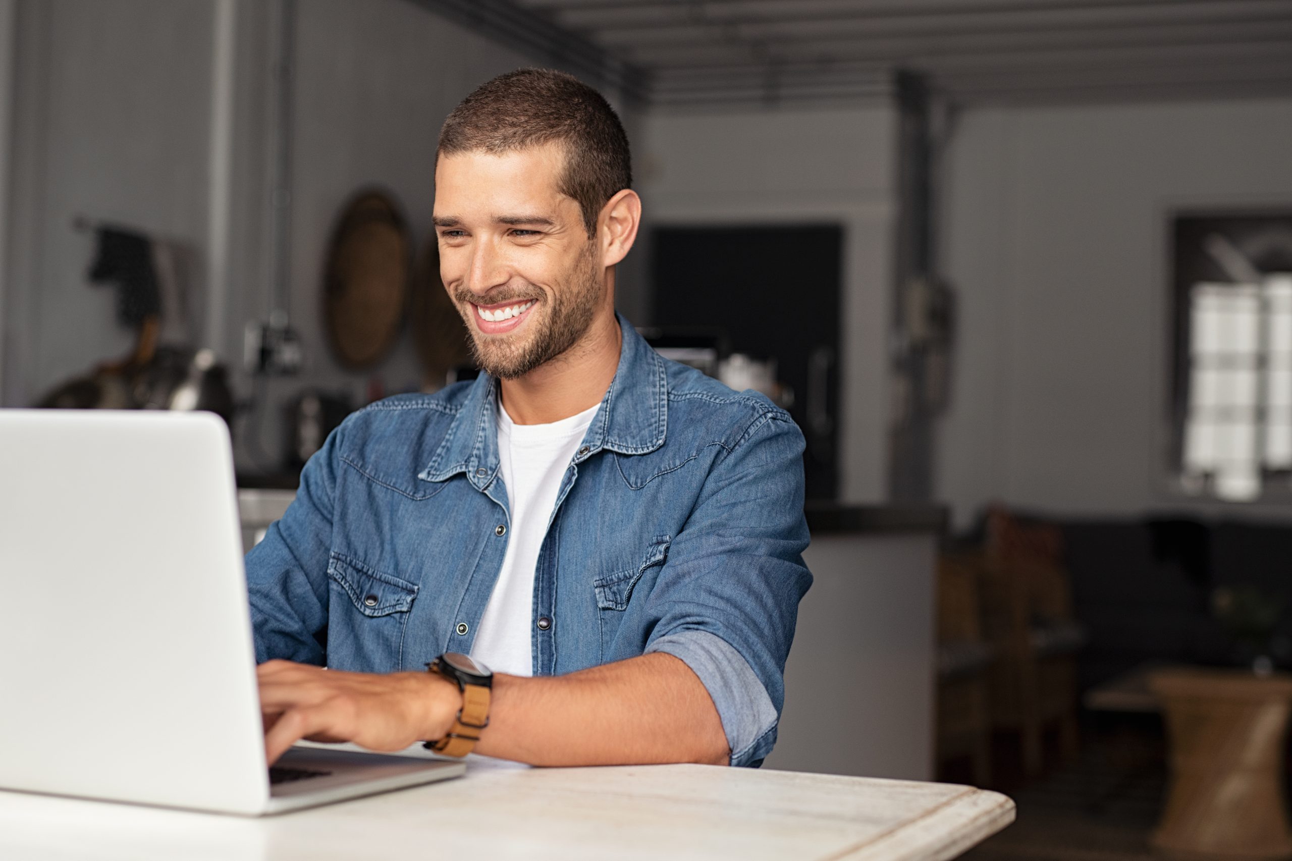 Caucasian male smiling on laptop | Loans