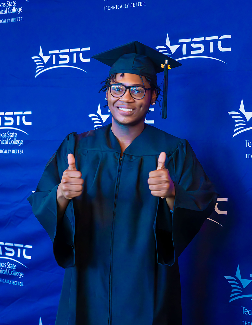 A male graduate posing in his cap and gown at the Summer 2024 commencement ceremony in Harlingen, Texas.