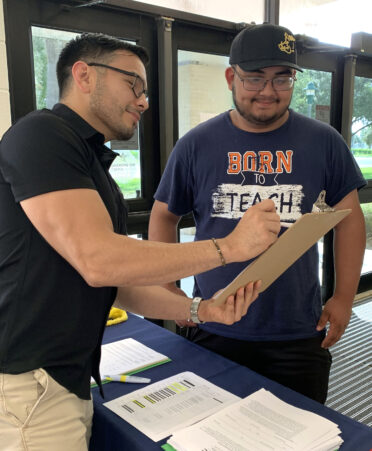 TSTC Mechatronics Technology student Julian Miranda (right) reviews his dorm contract on move-in day with Daniel Garza, TSTC’s coordinator of Residence Life and Engagement in Harlingen.
