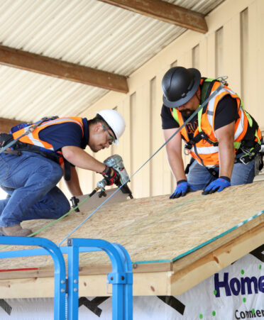TSTC Building Construction Technology students Jose Luis Garcia (left) and Jose Garcia work on sheathing a roof during a recent lab session.