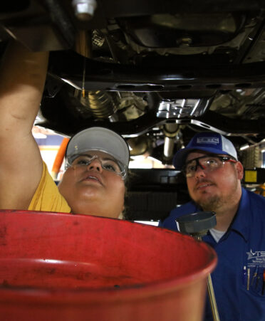 TSTC Automotive Technology instructor Bruce Schmitt (right) teaches Belinda Sosa, a cosmetology teacher at Harlingen CISD, how to drain oil from an automobile during TECHcelerate, a technical education conference recently held at TSTC’s Harlingen location.