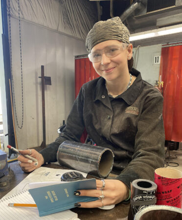 woman sitting in a welding shop