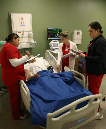 TSTC Nursing students (left to right) Analisa Campos, Gina Ciumacenco and Nora Avila discuss and notate the vital signs and blood pressure of a medical manikin during a recent lab session.