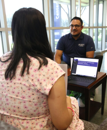 Carlos Ortega (right), a TSTC admissions advisor, helps Ximena Gonzalez enroll in TSTC’s Surgical Technology program at the Harlingen campus.