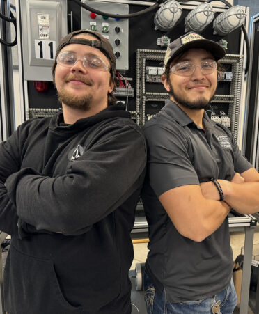 two men standing in front of equipment