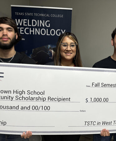 three people holding check