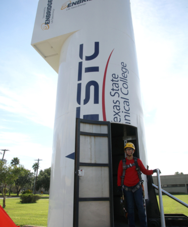 Yasmin Lara, a Wind Energy Technology student at TSTC’s Harlingen campus, stands on the new wind turbine training simulation trailer that the program’s students will use to practice their climbing skills.