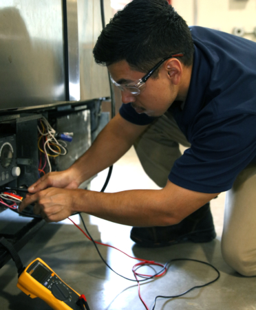 Anthony Mata, an HVAC Technology student at TSTC’s Harlingen campus, checks the voltage on a defrost timer during a recent lab session.