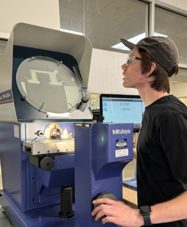 TSTC student Garrett Roeder uses a comparator that uses light to create shadows of a part to evaluate measurements of a part during a recent lab session at TSTC. (Photo courtesy of TSTC.)