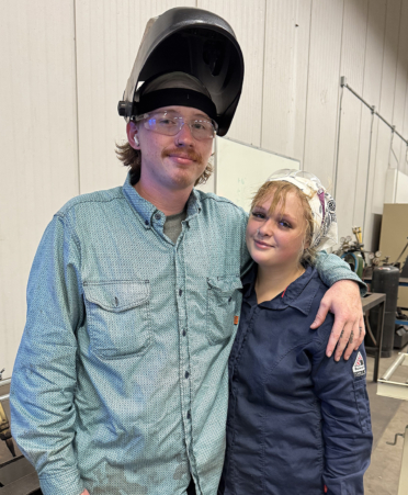 couple standing welding lab