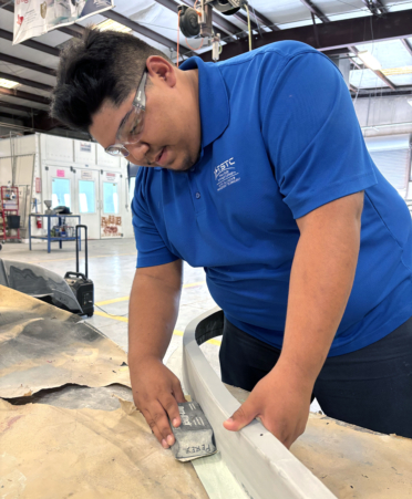 Anthony Luna, a TSTC Auto Collision and Management Technology student at TSTC’s Harlingen campus, uses a sanding block to repair fiberglass on a bumper panel during a recent lab session.