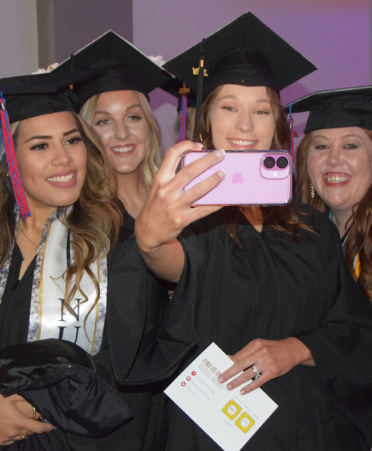 four graduates taking a selfie