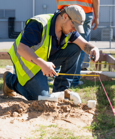 A Plumbing and Pipefitting Technology student at Texas State Technical College measures PVC pipe for installation during a recent lab session at the Waco campus.