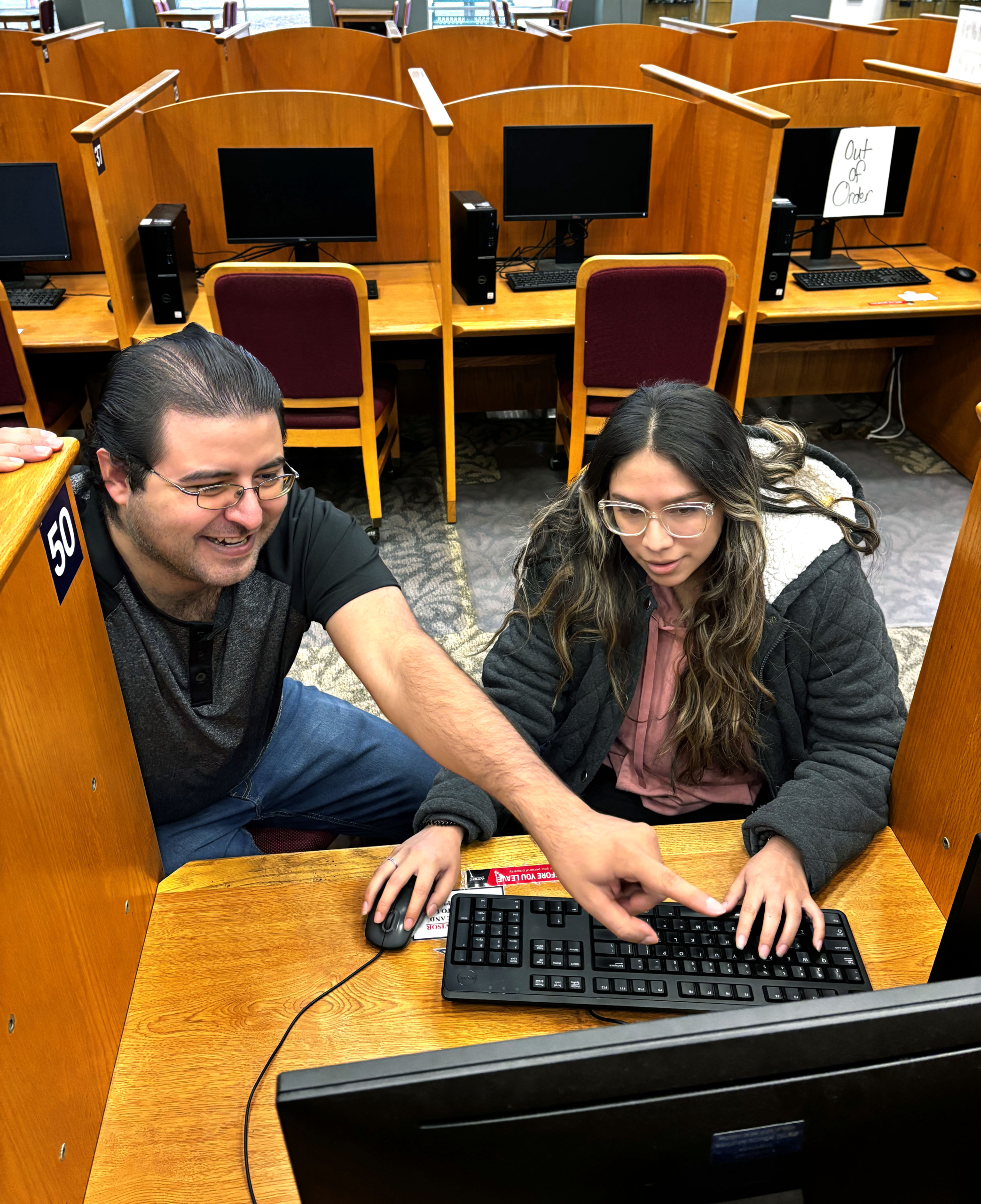 Gabriel Garcia (left), a TSTC Cybersecurity student, helps Mayra Frias-Cervantes, a TSTC Education and Training student, look for her spring 2025 class schedule on a computer in the Learning Resource Center at TSTC’s Harlingen campus.