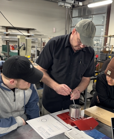 Precision Machining Technology instructor John Wythe, center, demonstrates how to use a telescoping gauge. (Photo courtesy of TSTC.)