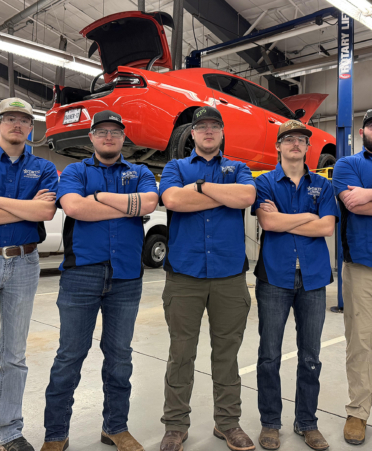 five men in blue shirt in auto shop