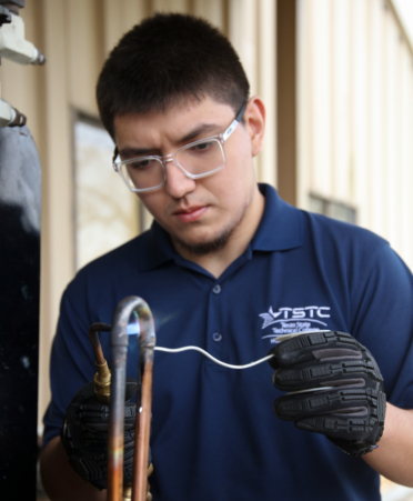 Luis Lugo, an HVAC Technology student at TSTC’s Harlingen campus, uses an oxygen acetylene torch to repair a copper tube during a recent lab session.