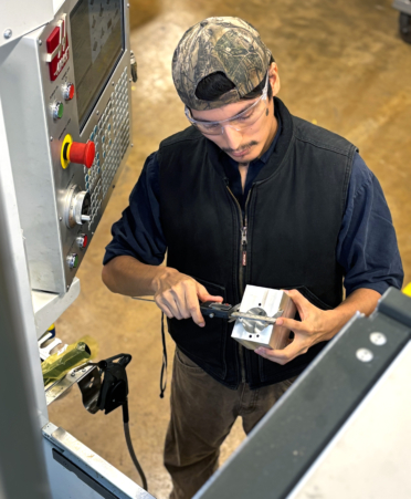 Edmundo Salazar, a Precision Machining Technology student at TSTC’s Harlingen campus, measures an aluminum part during a recent lab session.