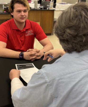 man in red shirt during an interview