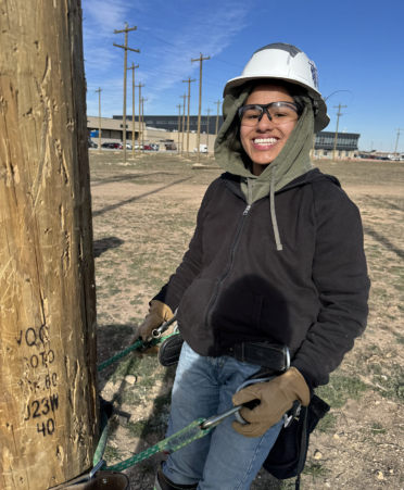 female in black jacket on electrical pole