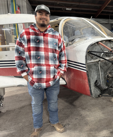 man in red and blue shirt standing next to airplane