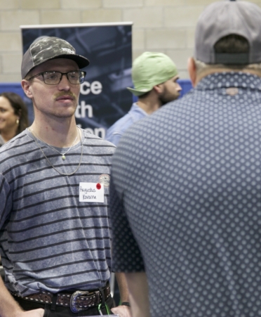 TSTC Williamson County Welding Technology student August Kovarna (left) talks to a prospective employer at the TSTC job fair in Waco on March 4.