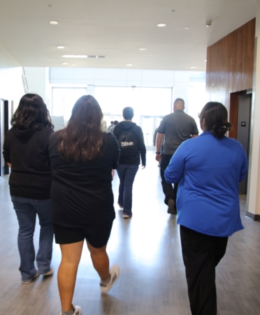 Students walk away from the camera with two women talking closest to it.