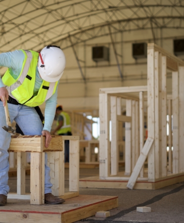 A TSTC Building Construction Technology student at the Waco campus hammers a nail into a frame during a lab session.