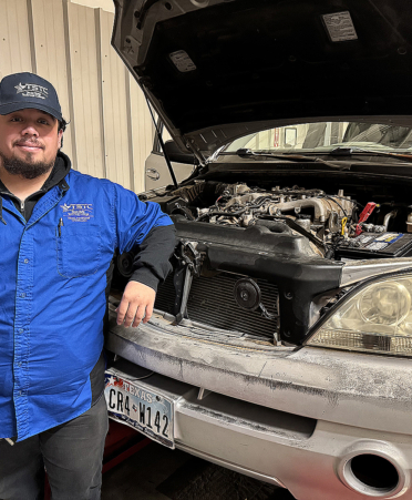 man standing next to car in blue shirt